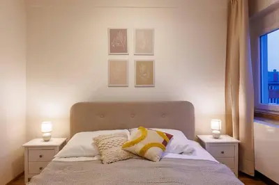 a bedroom with a bed with two night stands and a window at 1 bedroom apartment with terrace and FREE parking near metro in Prague