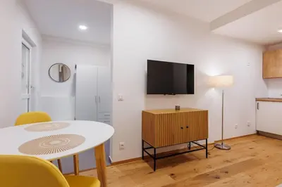a living room with a table and a tv on a wall at 1 bedroom apartment with terrace and FREE parking near metro in Prague
