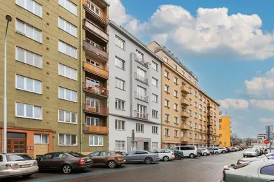 a row of buildings on a city street with cars parked at 1 bedroom apartment with terrace and FREE parking near metro in Prague