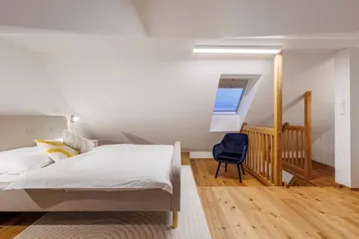 a bedroom with a bed and a blue chair at 2 rooms apartment with terrace and FREE parking near metro in Prague