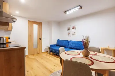 a living room with a table and a blue couch at 2 rooms apartment with terrace and FREE parking near metro in Prague