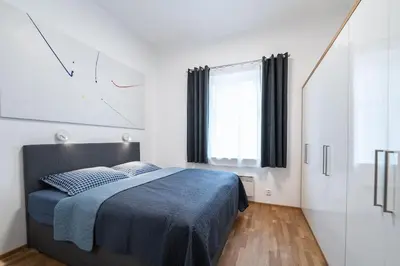 a bedroom with a bed and a clock on the wall at Apartmán Praha Žižkov - DZ RENT in Prague