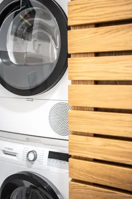 a washing machine sitting next to a stack of wood at Apartmán Praha Žižkov - DZ RENT in Prague