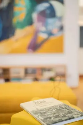 a book sitting on top of a yellow couch at Apartmán Praha Žižkov - DZ RENT in Prague