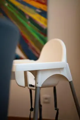 a white chair sitting in front of a painting at Apartmán Praha Žižkov - DZ RENT in Prague