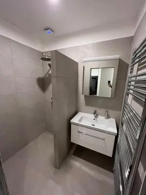 a white bathroom with a sink and a mirror at Apartmán Praha Žižkov - DZ RENT in Prague