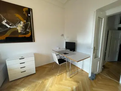 a desk with a computer and a chair in a room at River View Apartment MANES in Prague