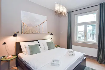 a bedroom with a bed with a bridge painting on the wall at Prague apartment Spalena in Prague