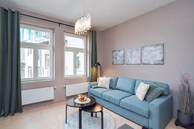 a living room with a blue couch and a table at Prague apartment Spalena in Prague