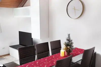 a dining room with a table and chairs and a clock at Riverside Palace Suites in Prague