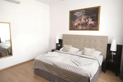 a white bedroom with a bed and a painting on the wall at Riverside Palace Suites in Prague