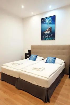 a bedroom with a large bed with a picture on the wall at Riverside Palace Suites in Prague