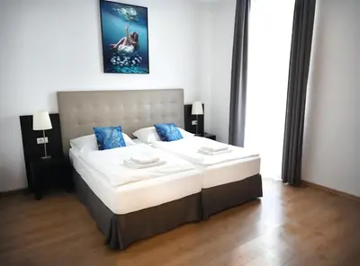 a bedroom with a large white bed with blue pillows at Riverside Palace Suites in Prague