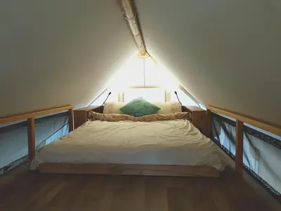 a small bed in a room with a light at Marina&Glamping Nova Zivohost in Neveklov