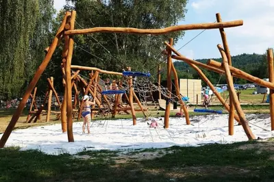 a group of people playing on a playground in the sand at Marina&Glamping Nova Zivohost in Neveklov
