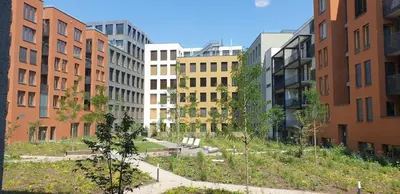 a row of buildings in a city with trees at Smichov city Apartments in Prague