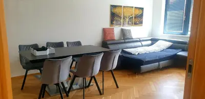 a living room with a couch and a table and chairs at Smichov city Apartments in Prague