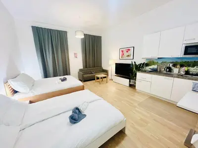a hotel room with two beds and a kitchen at Cozy Design Homestay right next to Wenceslas Square in Prague