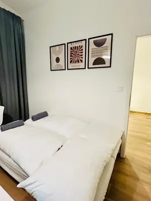 two beds in a room with three pictures on the wall at Cozy Design Homestay right next to Wenceslas Square in Prague