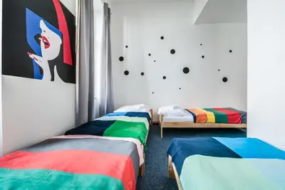 a room with three beds with colorful blankets at Pop Art Rooms in Prague