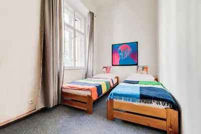 two twin beds in a room with a window at Pop Art Rooms in Prague