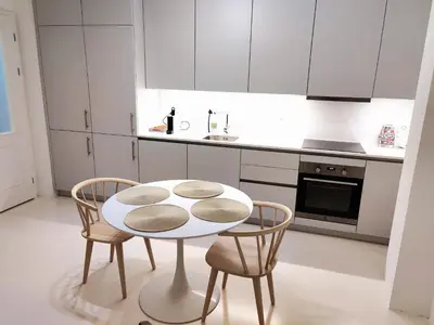 a white kitchen with a table and two chairs at Central Studio with Private Courtyard in Prague
