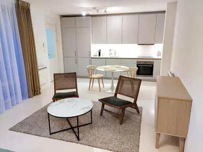 a living room with a table and chairs and a kitchen at Central Studio with Private Courtyard in Prague