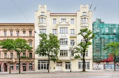 a building on a street with trees in front of it at Central Studio with Private Courtyard in Prague