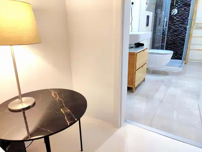 a room with a table and a lamp and a bathroom at Central Studio with Private Courtyard in Prague