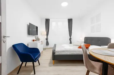 a bedroom with a bed and a table with a blue chair at 2 bedrooms apartment near the metro in Prague