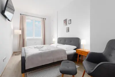 a bedroom with a bed and a chair and a window at 2 bedrooms apartment with kitchen near the subway in Prague