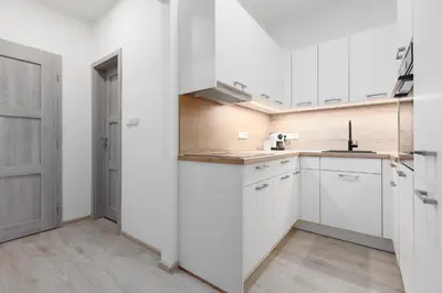 an empty kitchen with white cabinets and a door at 2 bedrooms apartment with kitchen near the subway in Prague