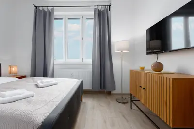 a bedroom with a bed and a large window at 2 bedrooms apartment with kitchen near the subway in Prague