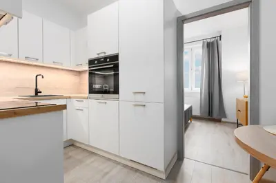 a kitchen with white cabinets and a stove at 2 bedrooms apartment with kitchen near the subway in Prague