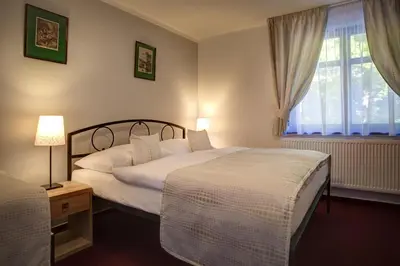 a hotel room with two beds and a window at Penzion Obora in Poděbrady