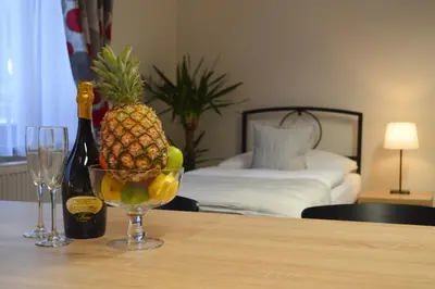 a bottle of champagne and a bowl of fruit on a table at Penzion Obora in Poděbrady