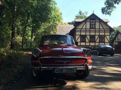 an old red car parked in front of a house at Penzion Obora in Poděbrady