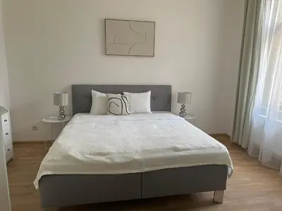 a bedroom with a large bed with two tables at Útulný byt v centru Prahy in Prague