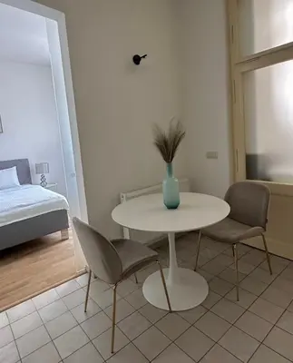 a white table with two chairs and a vase on it at Útulný byt v centru Prahy in Prague