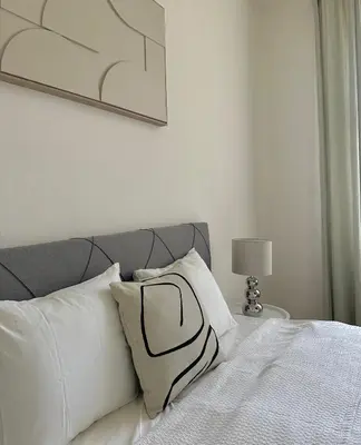 a bed with white pillows and a picture on the wall at Útulný byt v centru Prahy in Prague