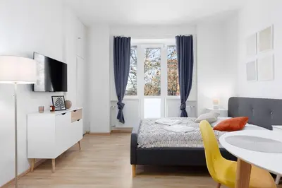 a bedroom with a bed and a table with a yellow chair at Quiet apartment with kitchen near the metro in Prague
