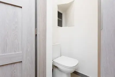 a bathroom with a white toilet and a door at Quiet apartment with kitchen near the metro in Prague