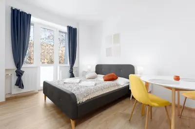 a bedroom with a bed and a table and chairs at Quiet apartment with kitchen near the metro in Prague