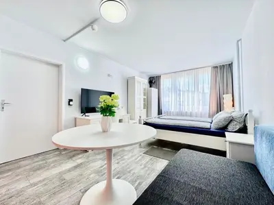 a living room with a table and a bed at Apartment Střížkov in Prague