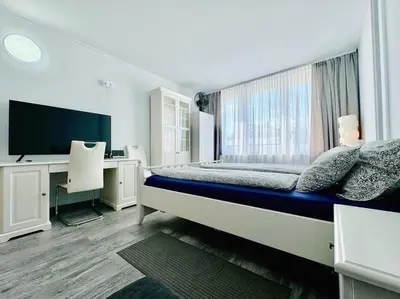 a bedroom with a bed and a desk and a computer at Apartment Střížkov in Prague
