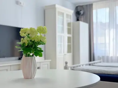 a white table with a vase with flowers on it at Apartment Střížkov in Prague