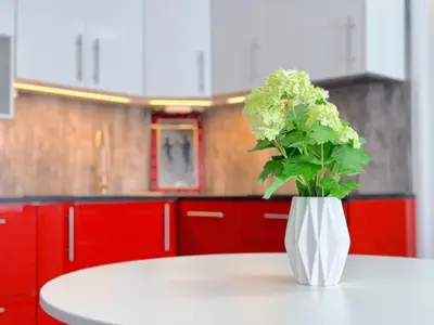 a white vase with flowers on a table in a kitchen at Apartment Střížkov in Prague
