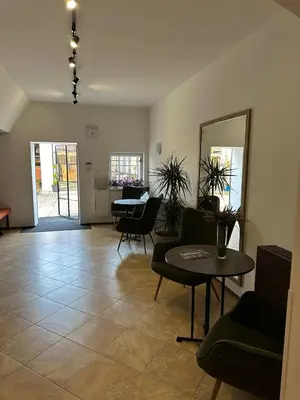 a living room with a table and chairs and a mirror at Golden Golem hotel & Spa in Prague