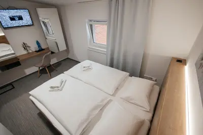 a bedroom with a bed with white sheets and a desk at Golden Golem hotel & Spa in Prague
