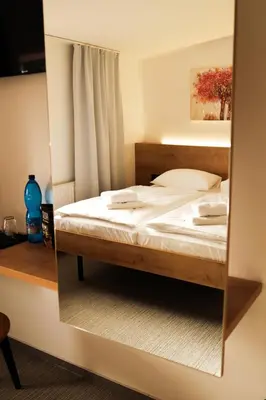 a mirror reflection of a bed in a bedroom at Golden Golem hotel & Spa in Prague